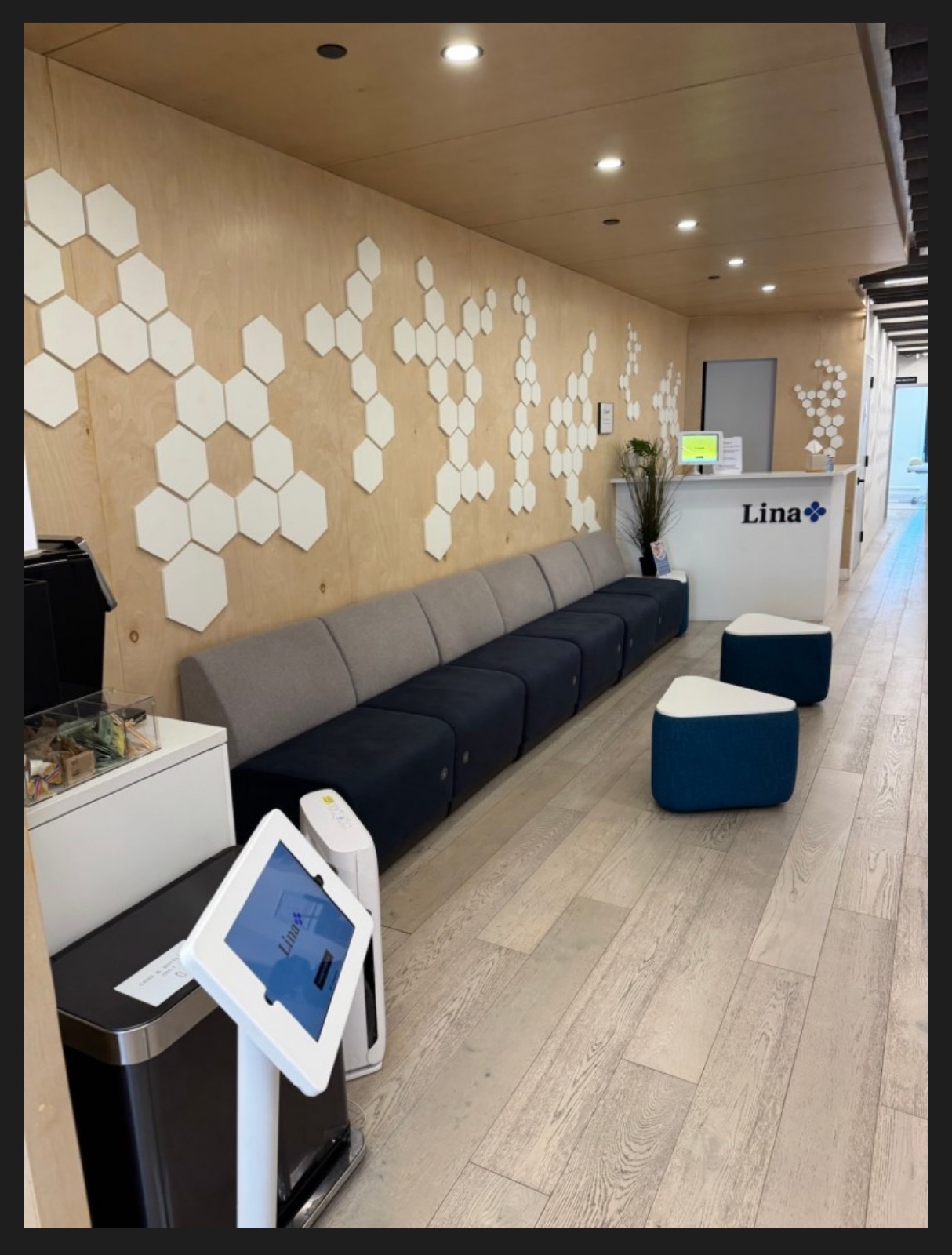 Waiting area at Robin Warner Neurology — light wood paneling with honeycomb wall art and modern navy seating